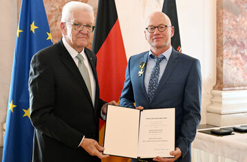 Zwei Personen präsentieren eine Urkunde